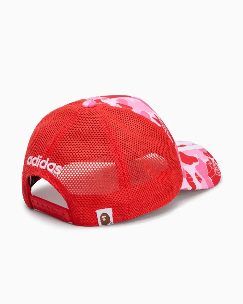 Red mesh adidas Originals x BAPE trucker hat with pink camouflage front panel and snapback closure
