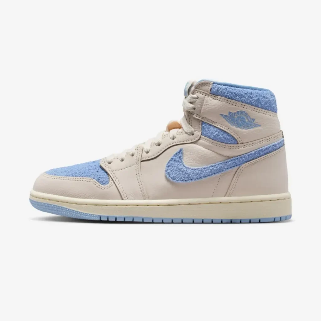 Air Jordan 1 High OG WMNS “Psychic Blue” sneaker in cream leather with soft blue textured Swoosh, collar, and toe box, shown in side profile against a clean studio background