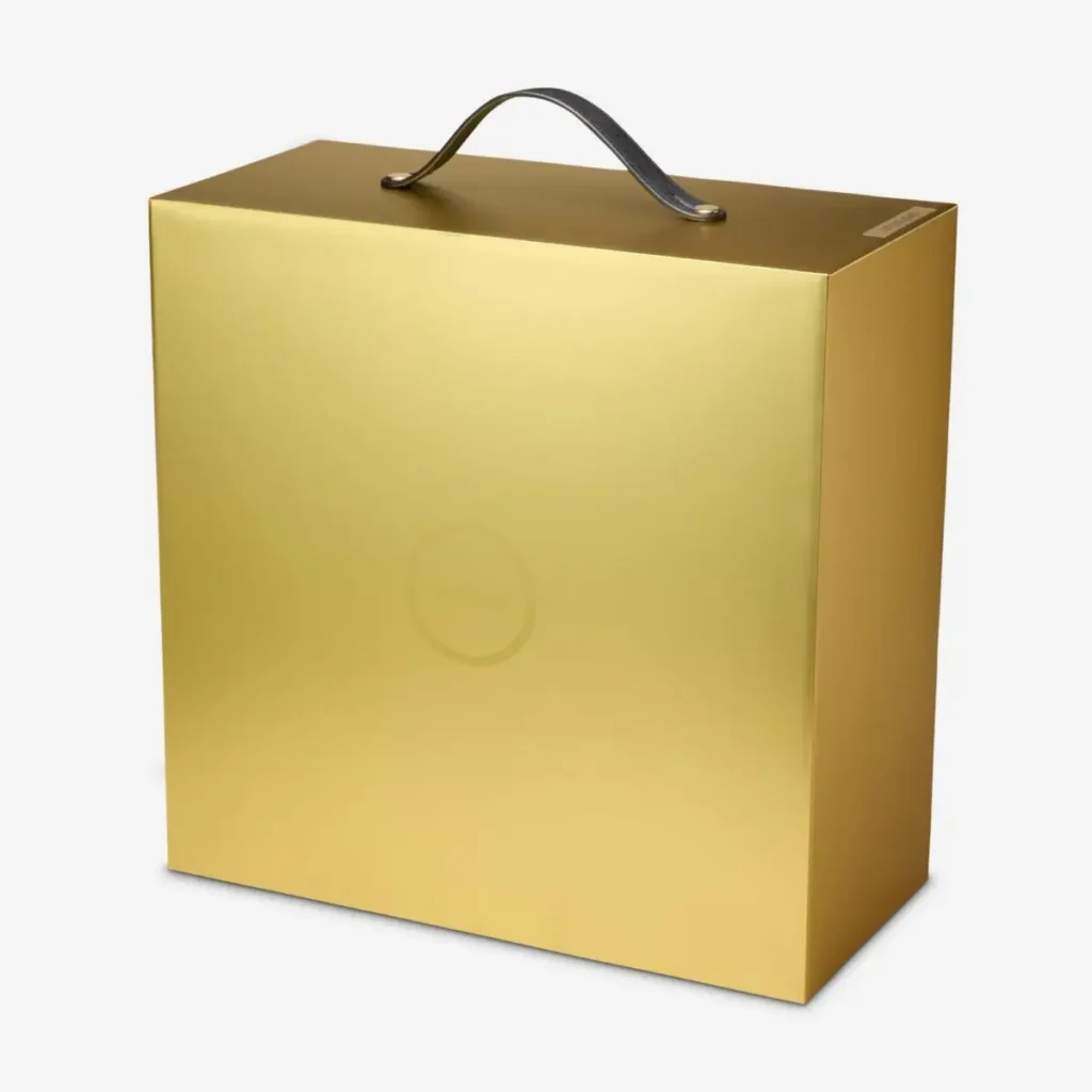 Gold presentation carrying case for the Nike LeBron 23 “LeBronto” sneaker featuring a metallic finish and black handle with subtle LeBron crown emblem