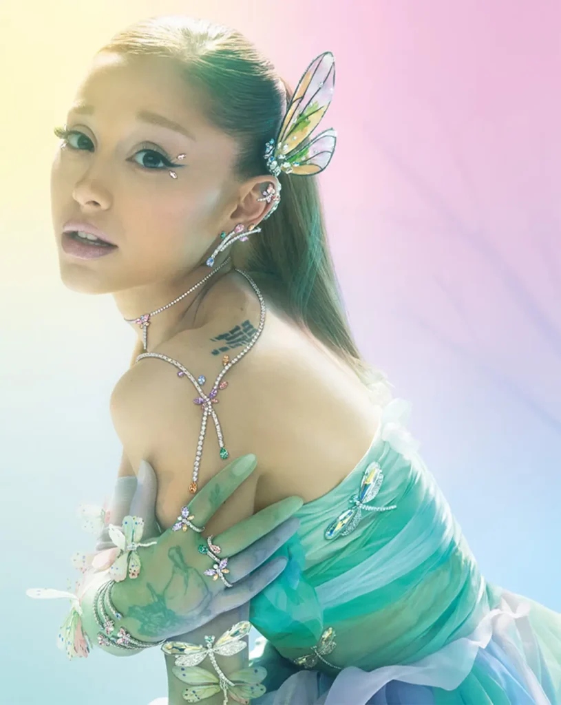 Ariana Grande in a luminous fairycore-inspired look featuring iridescent butterfly accessories, delicate jewelry, and a soft gradient backdrop, evoking an ethereal, fantasy-driven aesthetic