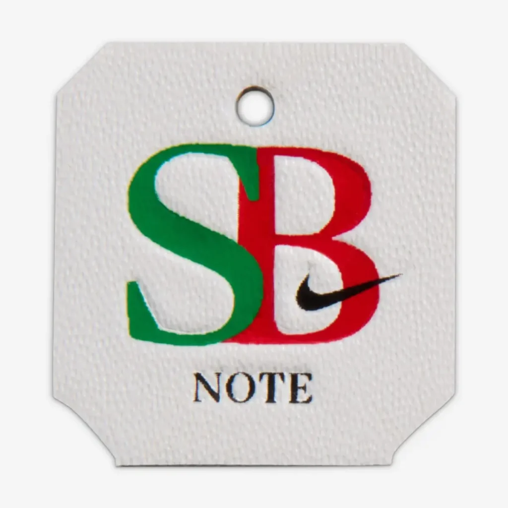 Co-branded NOTE x Nike SB hangtag featuring split green and red “SB” lettering with a black Swoosh and “NOTE” text below on a textured white background