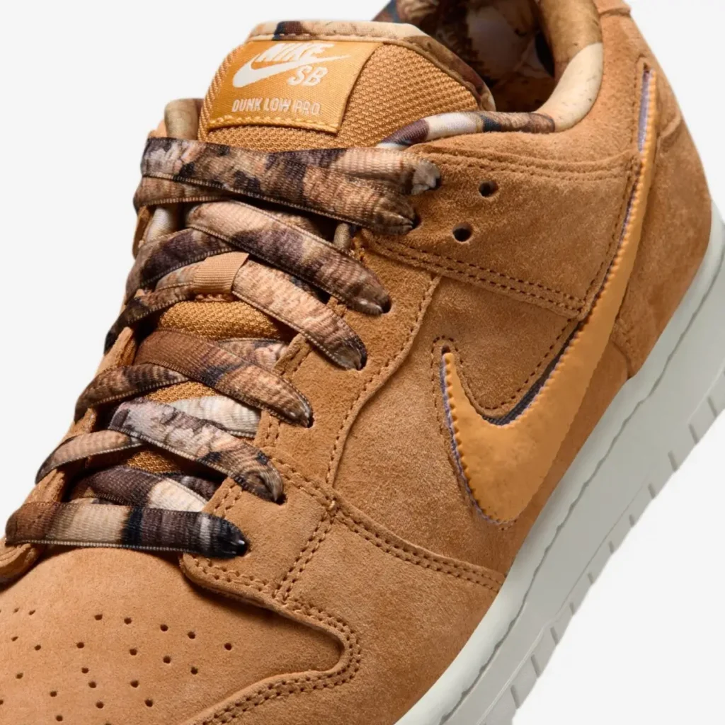 Close-up of NOTE x Nike SB Dunk Low “Brew & Biscuits” highlighting biscuit-brown suede overlays, textured tonal Swoosh, marbled coffee-toned laces, perforated toe box, and Nike SB tongue label detail