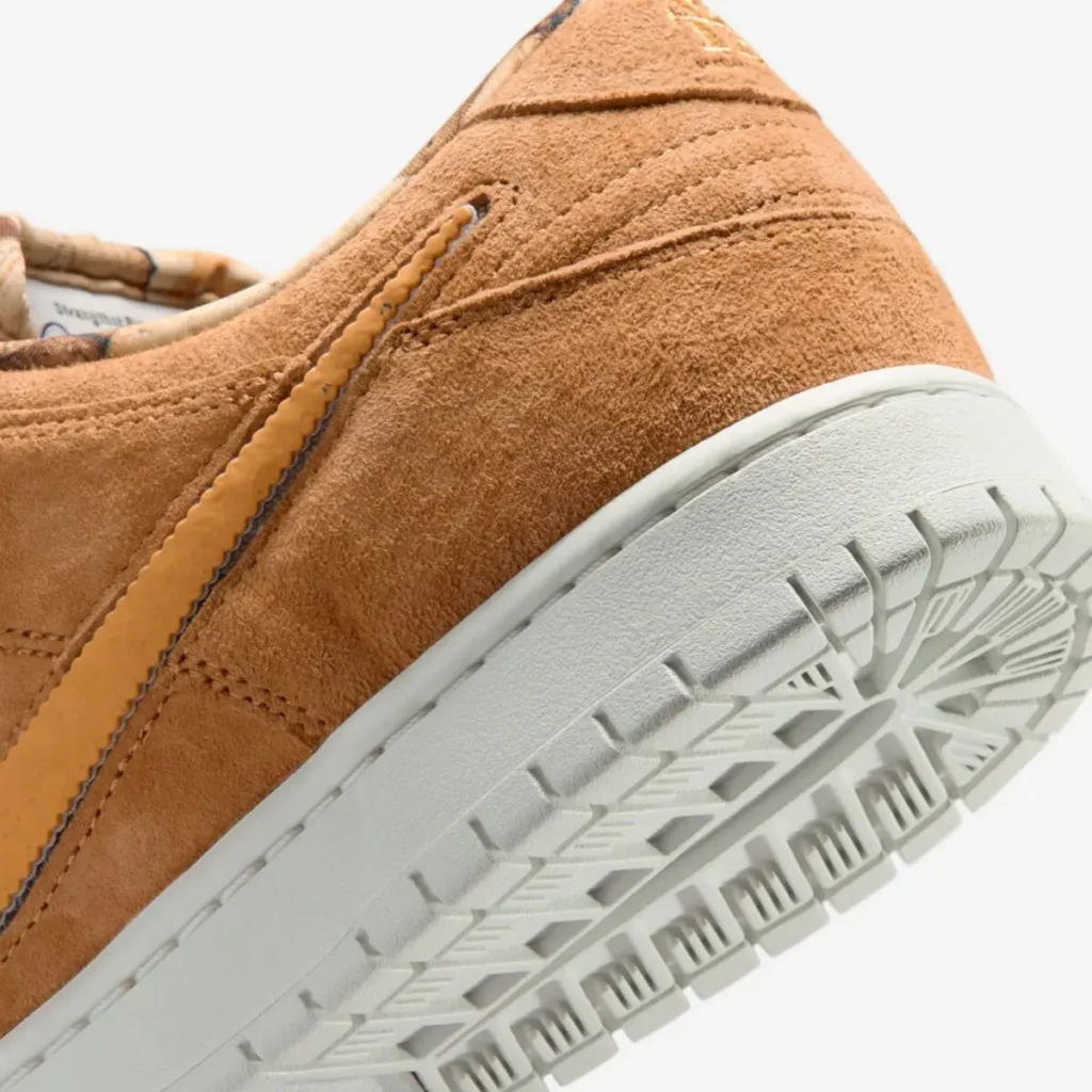 Close-up of NOTE x Nike SB Dunk Low “Brew & Biscuits” heel and outsole, featuring textured biscuit-brown suede, ridged tonal Swoosh detail, and off-white rubber sole with classic Dunk traction pattern