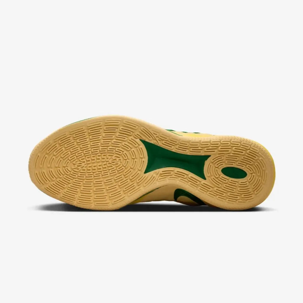 Bottom view of the Nike Sabrina 3 “Oregon Ducks” basketball shoe showing a gum rubber outsole with multidirectional traction pattern and green midfoot support detail