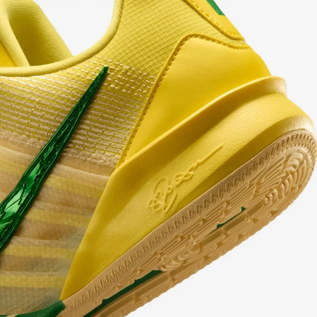 Close-up of the Nike Sabrina 3 “Oregon Ducks” basketball shoe heel featuring a yellow midsole with Sabrina Ionescu’s signature, green Nike Swoosh detail, and gum rubber outsole