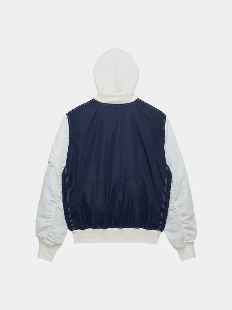 Rear view of lightweight Alpha Industries L-2B relaxed varsity flight jacket in navy and off-white, featuring a smooth nylon back panel, contrasting sleeves, attached hood, and ribbed hem and cuffs with a clean, minimal finish