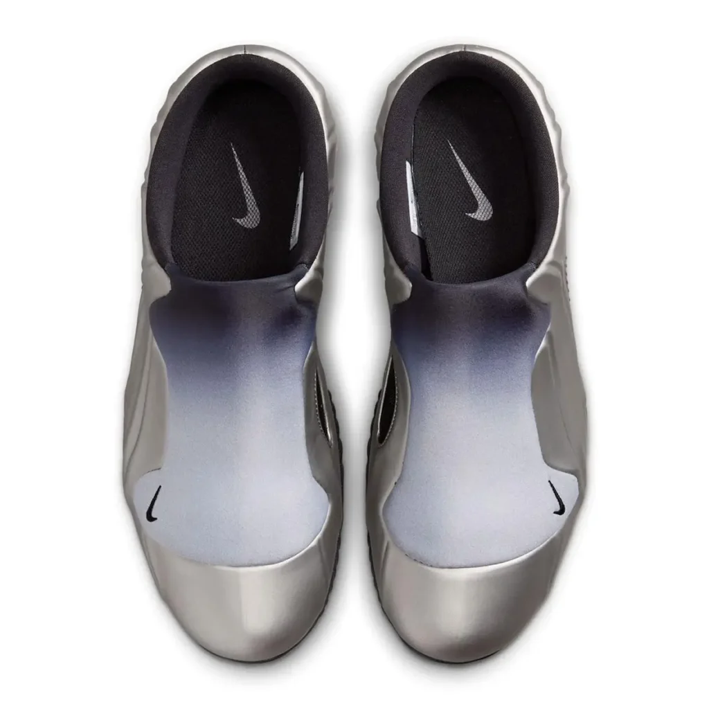 Top-down view of Nike Clogposite “Metallic Dark Grey” highlighting the silver gradient shroud, open-heel mule construction, black mesh lining, and Swoosh-branded insoles