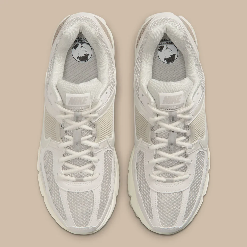 Top-down view of the Nike Zoom Vomero 5 “Phantom,” showcasing breathable mesh uppers, tonal lace system, and layered synthetic panels in soft cream hues, with subtle Nike branding on the tongue and insole