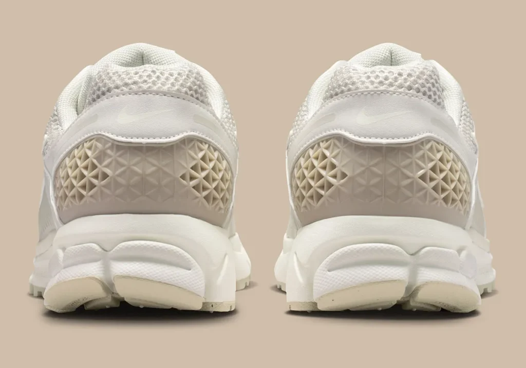 Rear view of the Nike Zoom Vomero 5 “Phantom,” highlighting the textured heel counter with geometric TPU detailing, padded mesh collar, and sculpted midsole in tonal cream hues for a clean, structured finish