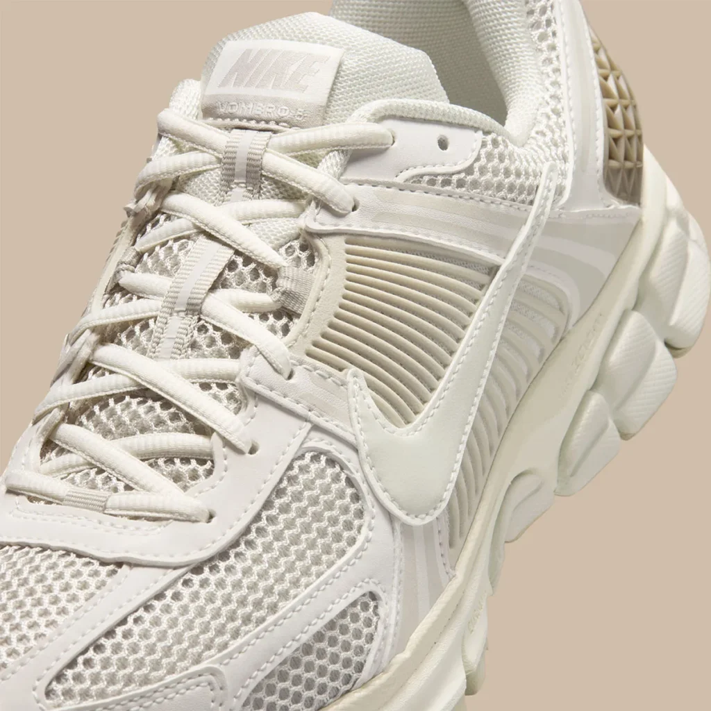 Close-up detail of the Nike Zoom Vomero 5 “Phantom,” highlighting breathable mesh underlays, tonal lacing system, sculpted side cage, and smooth synthetic overlays in layered cream hues