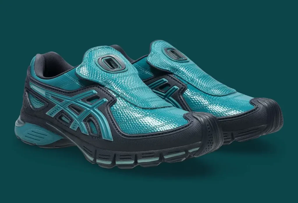 Pair shot of the OTTO 958 x ASICS Gel-SD Arzachotto in teal and black, featuring a glossy textured upper, laceless slip-on design with elongated tongue flaps marked by cut-out “O” details, layered black overlays, and sculptural midsoles with segmented cushioning and integrated ASICS Tiger Stripes