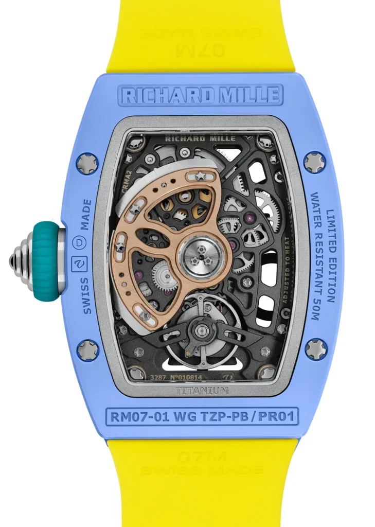 Blue ceramic Richard Mille RM 07-01 watch featuring a skeletonized automatic movement with visible gears and gold rotor, paired with a bright yellow rubber strap and turquoise crown detailing
