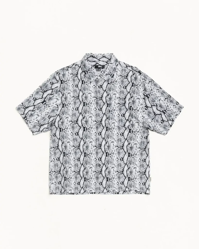 Black and white short-sleeve button-up shirt featuring an all-over snakeskin pattern with a relaxed collar and straight hem