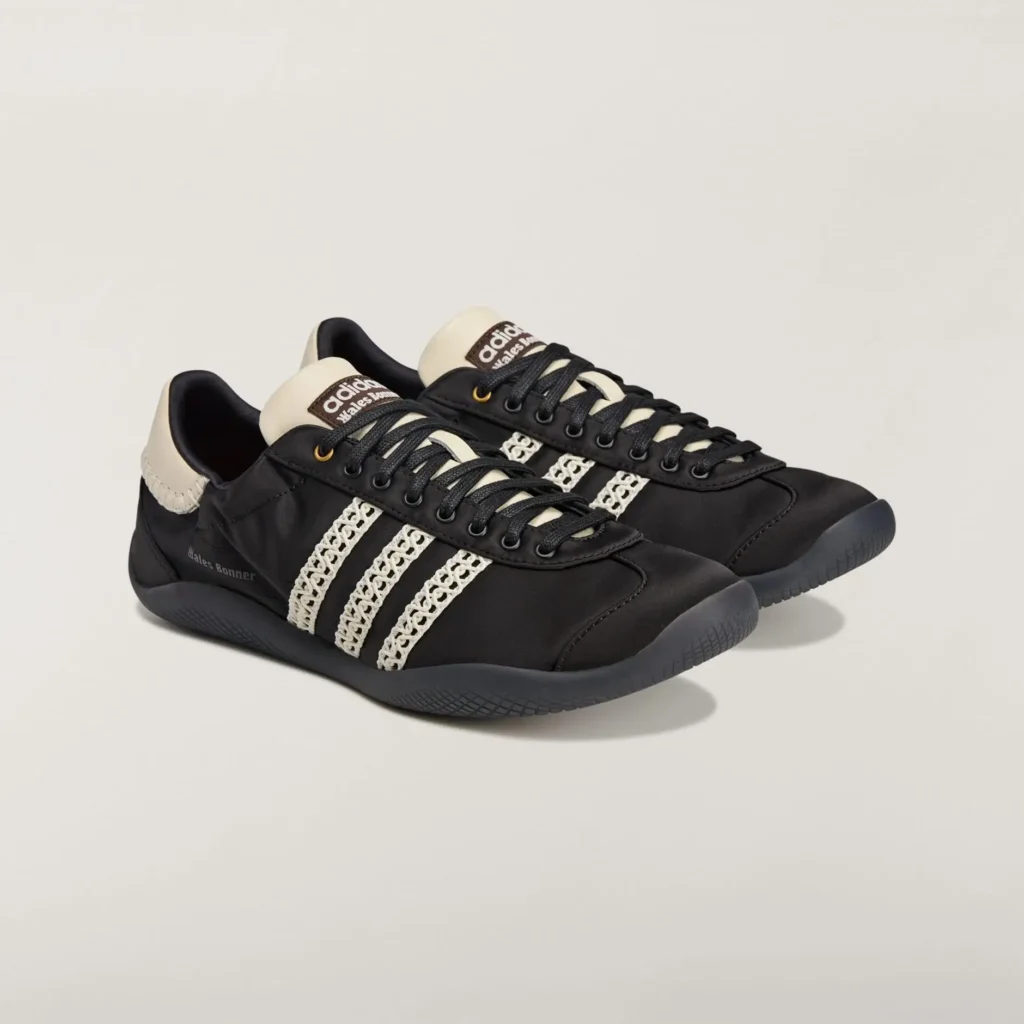 Wales Bonner adidas Karintha sneakers in black leather with crochet three stripes, cream heel tab, and tonal laces, shown in a clean studio product shot