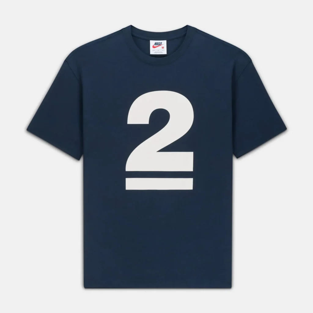 Navy short-sleeve T-shirt with a clean, minimal design, featuring a large white “2” graphic centered on the chest with two horizontal bars beneath it. The classic crewneck silhouette and smooth cotton finish emphasize a bold yet understated, graphic-driven aesthetic