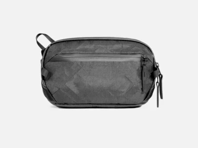 Aer Day Sling 4 Ultra front view in grey technical fabric, showcasing a clean rectangular profile, weather-resistant zip pocket, and minimalist hardware against a neutral background