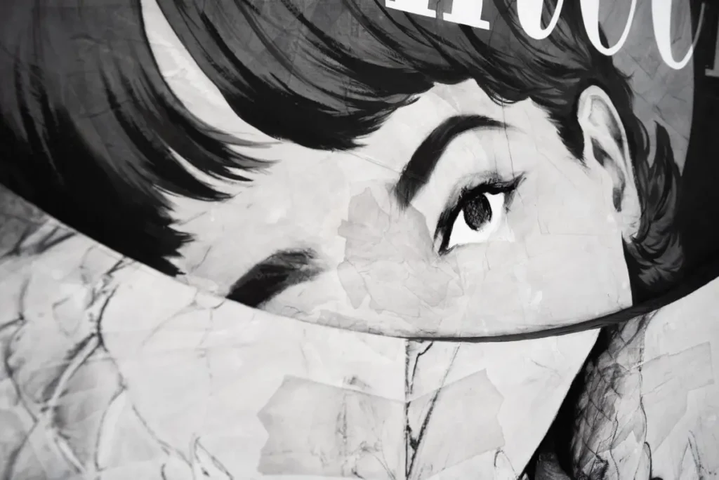 Black-and-white mixed media portrait by Anna Park showing a fragmented female face with a single sharply defined eye, partially obscured by layered paper textures and visible creases