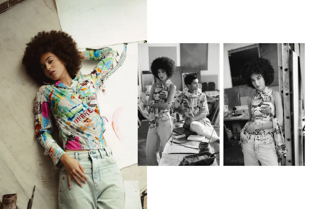 A collage-style fashion composition set inside an artist’s studio features a woman with a voluminous afro wearing a vibrant, Basquiat-inspired printed shirt and light-wash jeans, reclining against a textured wall with a relaxed, expressive pose. To the right, two black-and-white inset images show her styled alongside a male model in a creative workspace, surrounded by canvases, tools, and scattered materials. The garments are covered in bold, graffiti-like graphics, layered text, and painterly color blocks, emphasizing an art-meets-fashion narrative. The overall layout blends color and monochrome imagery, evoking a behind-the-scenes editorial moment where clothing, identity, and artistic process intersect