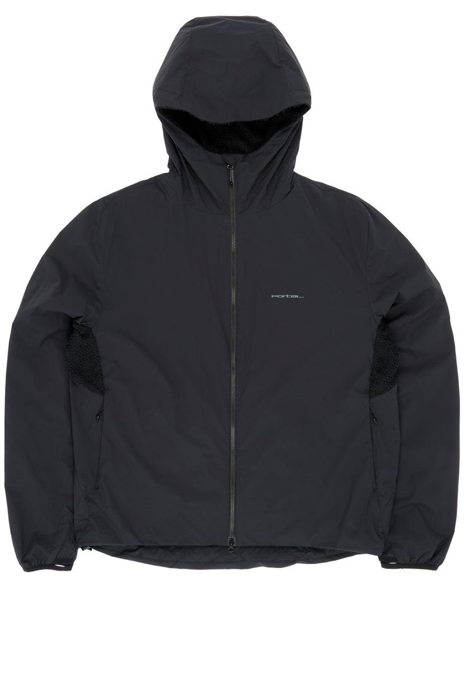 Front view of a black hooded technical jacket on a plain background, featuring a full-length zipper, structured hood, and subtle paneling. The design includes side zip pockets, textured underarm ventilation panels, and a small tonal logo on the chest, emphasizing a clean, minimalist performance aesthetic