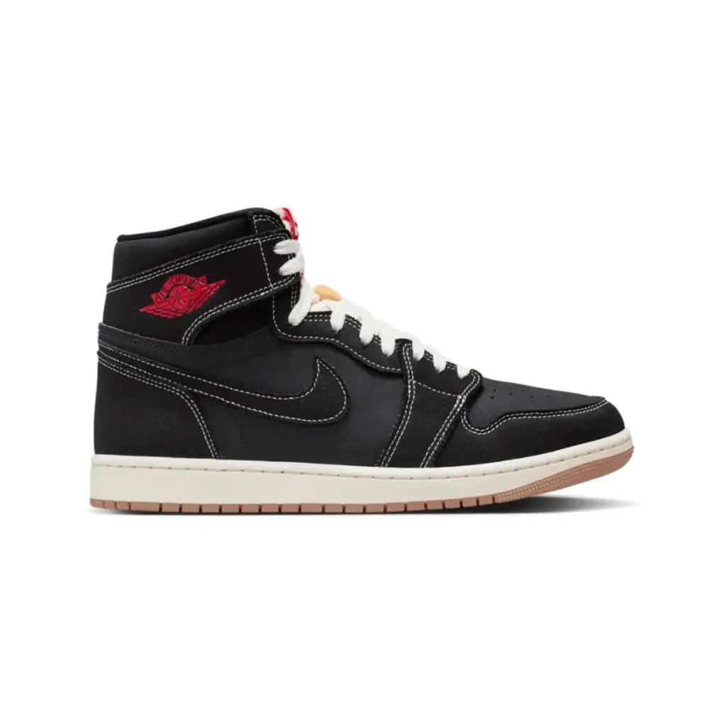 Side profile of the Air Jordan 1 High OG “Flight Club” (2026) in black leather with contrast white stitching, red Wings logo on the collar, white laces, Sail midsole, and gum outsole against a neutral background