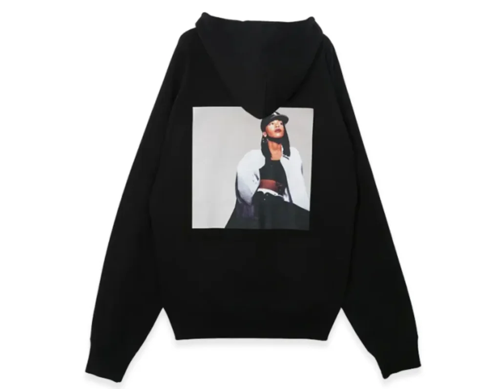 Black sacai hoodie featuring a large back print portrait of Aaliyah in a cap, centered on the garment against a clean, minimal studio background