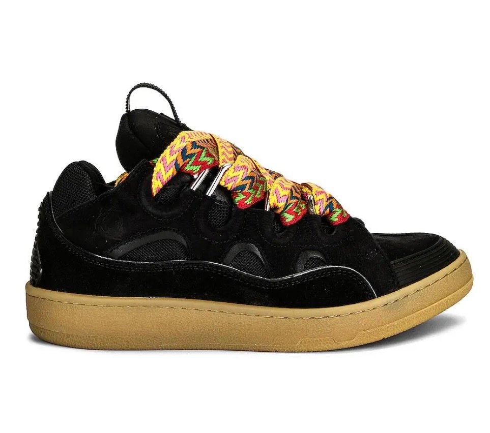 Lanvin Curb shoe in black suede on a white background, featuring oversized silhouette, cutout panels, multicolor chevron-pattern laces, and a gum rubber sole
