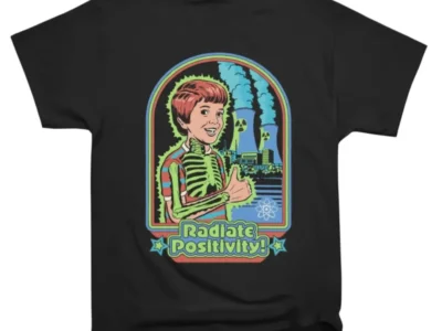 Steven Rhodes Radiate Positivity T-shirt – retro cartoon design with skeleton boy, nuclear plant, and 'Radiate Positivity!' text on a black tee