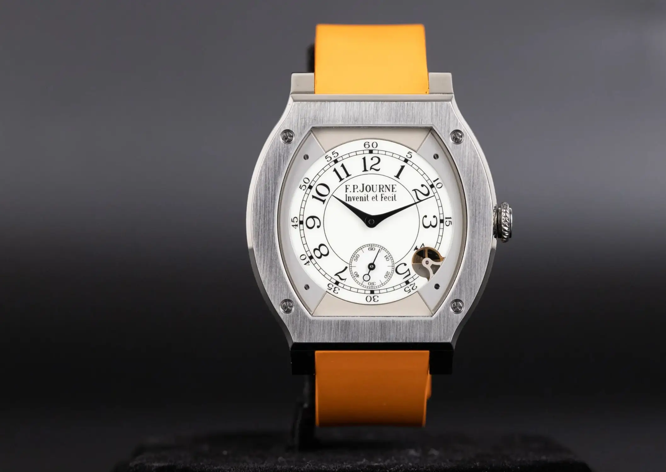 F.P. Journe Élégante 48 titanium tortue-shaped watch with white dial, black hands, small seconds subdial, visible motion detector aperture, and orange rubber strap against dark gradient background