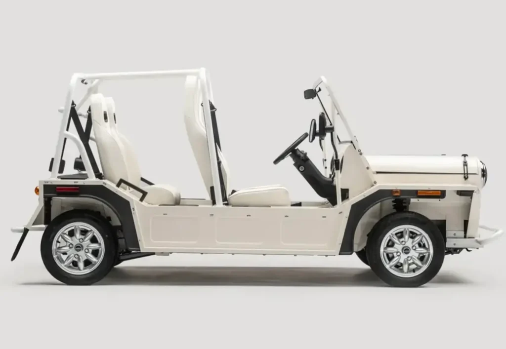 Side profile of MOKE GEN 1 EV in white, showing open-air structure, exposed roll frame, minimal body panels, and compact electric vehicle design