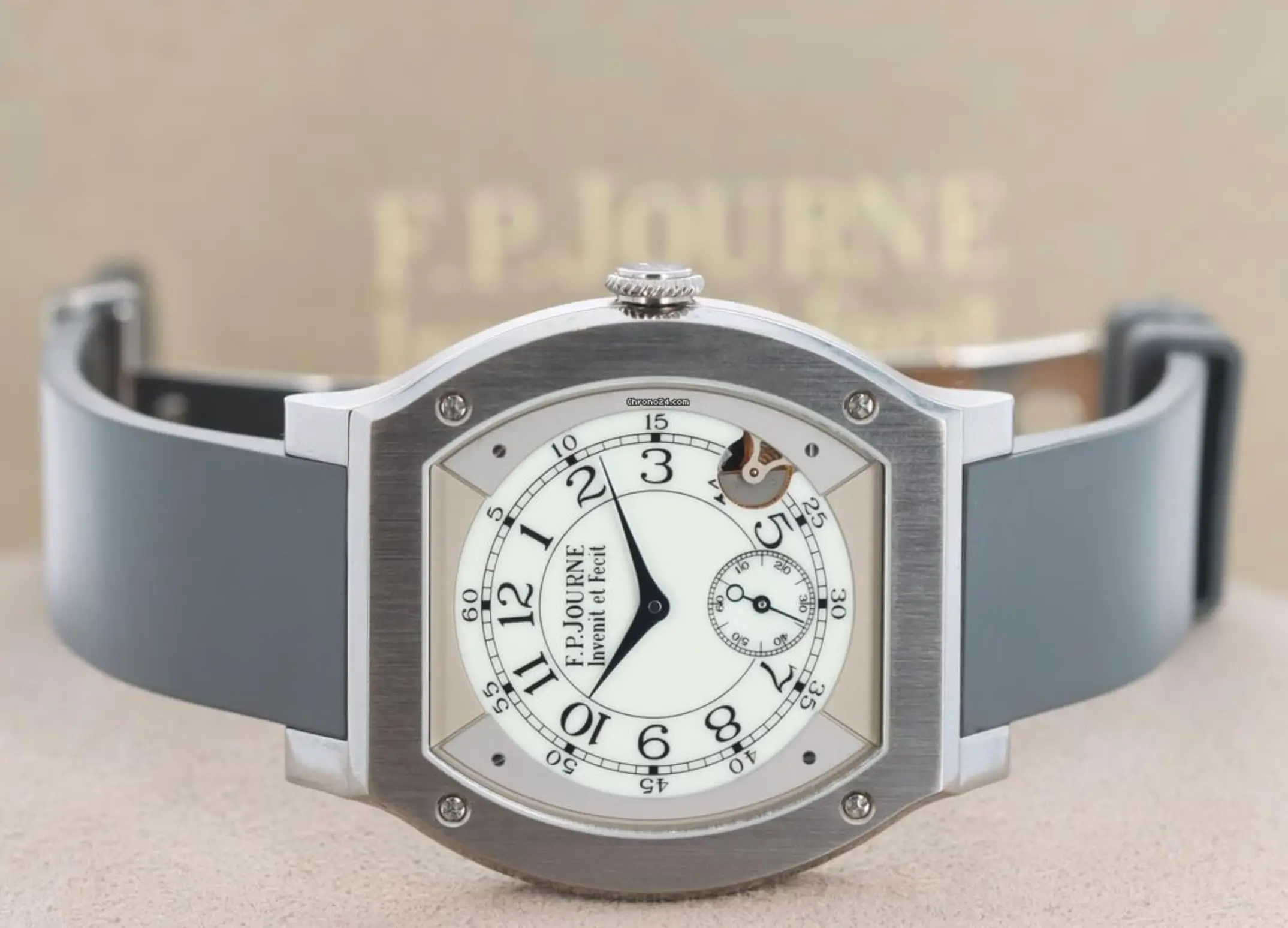 F.P. Journe Élégante 48 titanium tortue-shaped watch with white dial, black hands, small seconds subdial, visible motion detector aperture, and grey rubber strap displayed horizontally with presentation box in background
