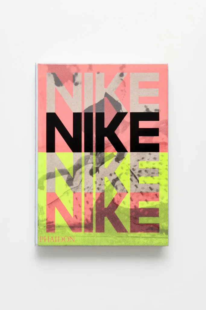 Front cover of Nike: Better Is Temporary by Phaidon featuring bold layered “NIKE” typography over a pink and neon green color-blocked background with textured archival imagery beneath