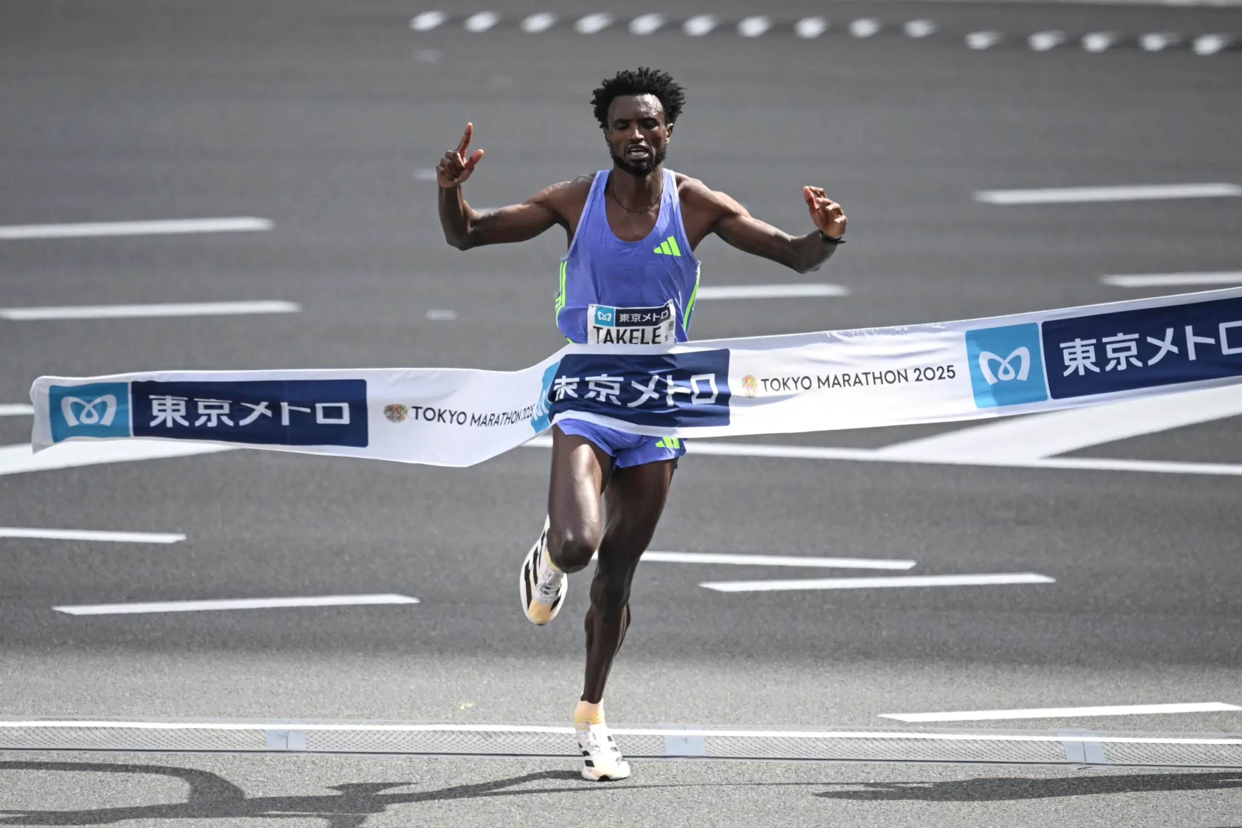 Tadese Takele winning the Tokyo Marathon, breaking the finish line tape in celebration