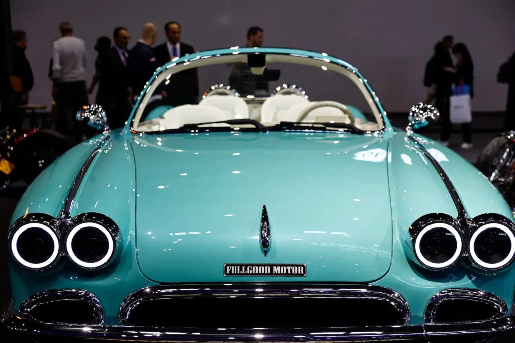 Front view of a turquoise Fullgood Motor retro-style convertible displayed at Auto China 2026, featuring circular LED headlights, chrome detailing, a minimalist open cabin with white seats, and a vintage-inspired design