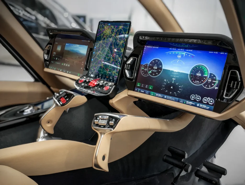 Close-up of a modern aircraft cockpit featuring multiple digital displays, touchscreen navigation maps, and advanced flight controls within a sleek, beige and black interior