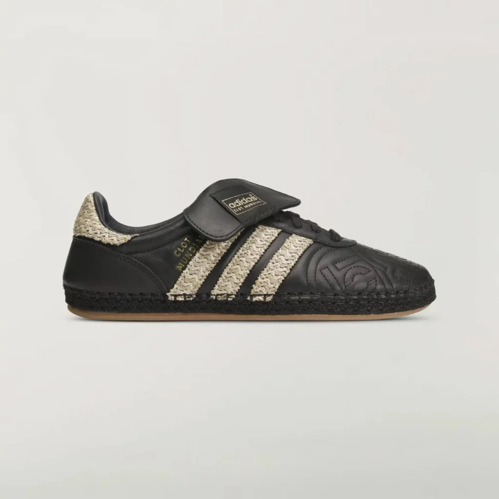 side profile of black adidas x CLOT Mundial shoe featuring raffia-woven Three Stripes, quilted leather upper, gold “CLOT Mundial” branding, fold-over tongue, and espadrille-style stitched sole