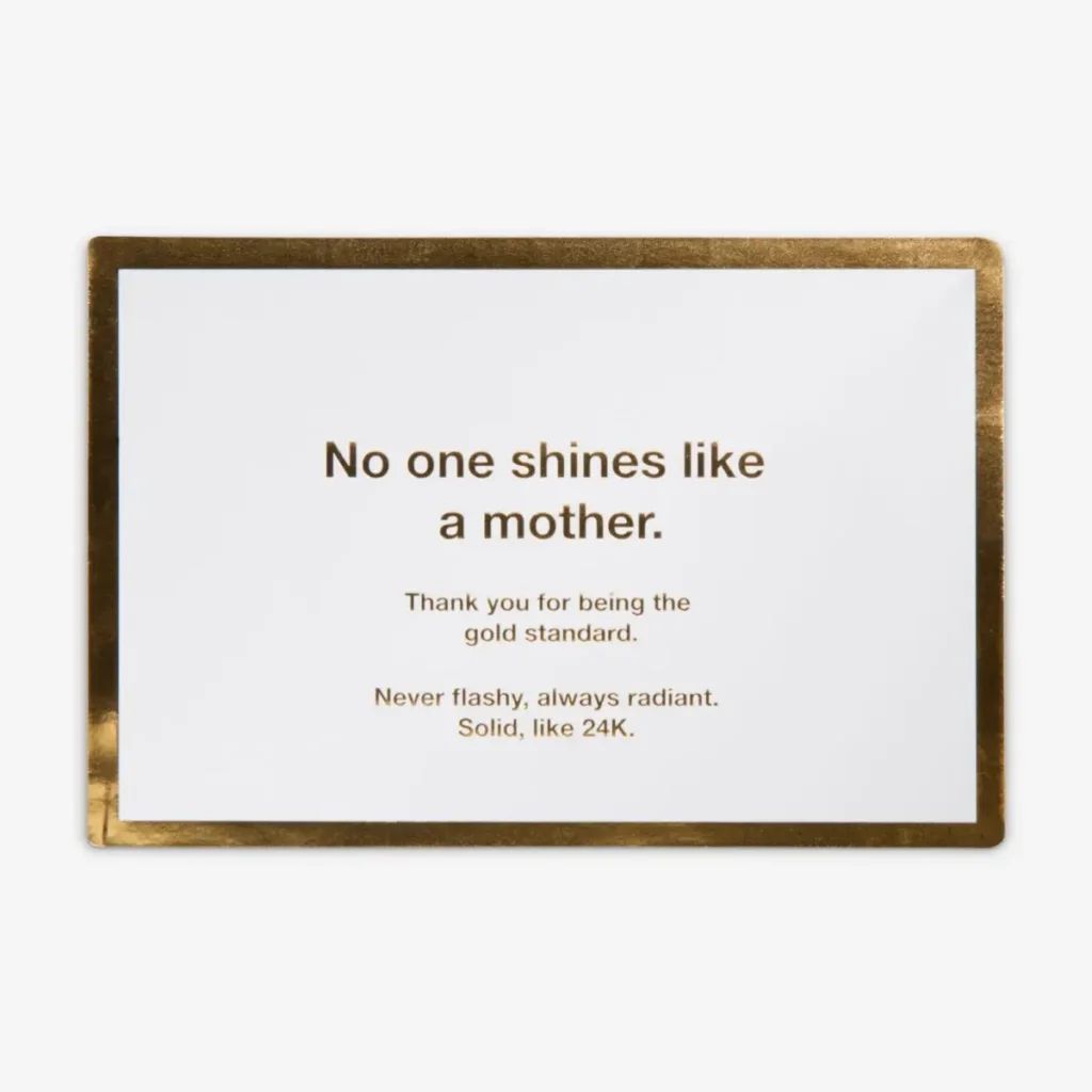 White card with a metallic gold foil border featuring a printed message: “No one shines like a mother. Thank you for being the gold standard. Never flashy, always radiant. Solid, like 24K.”