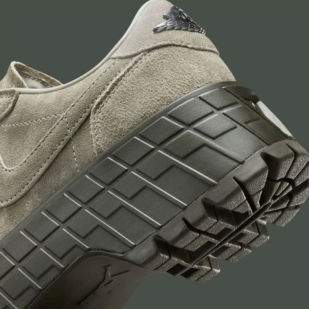 Air Jordan 1 Low Brooklyn “Cargo Khaki” close-up showing textured suede upper in muted khaki tone with embossed Swoosh, metallic Wings logo at the heel, and chunky dark olive platform outsole featuring deep, rugged tread pattern