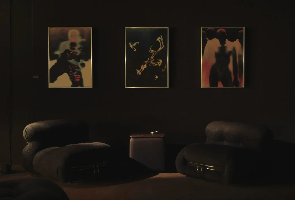 Seating area inside Spotify’s London Listening Lounge featuring sculptural lounge chairs and framed abstract artwork in a dimly lit acoustic interior