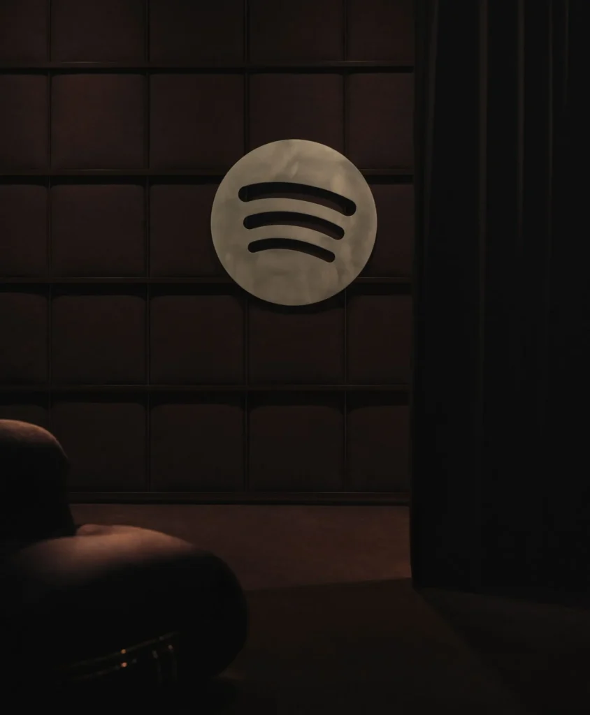 Spotify logo mounted on an acoustic panel wall inside the London Listening Lounge, set within a dimly lit, sound-optimized interior