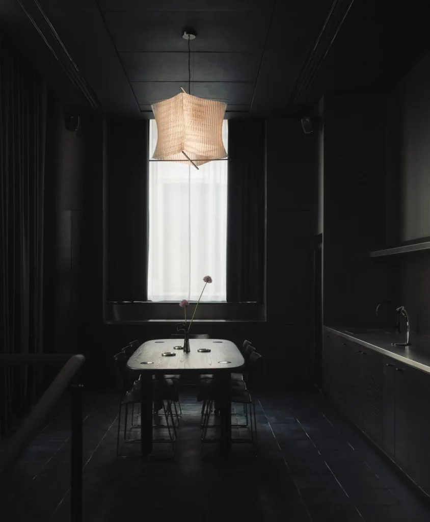 Private dining-style room inside Spotify’s London Listening Lounge featuring a central table, soft pendant lighting, and a dark, acoustically treated interior