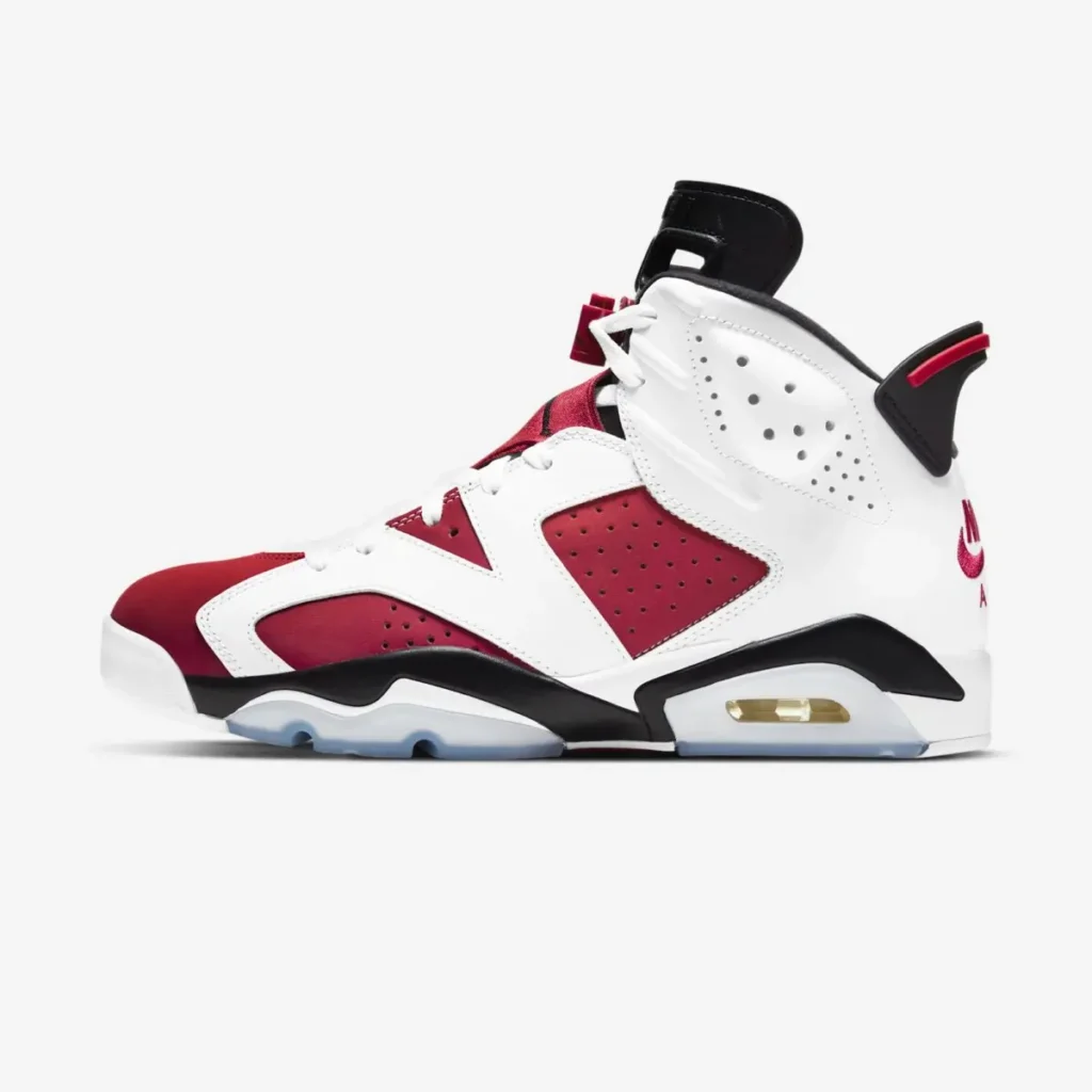 White, red, and black Air Jordan 6 “Carmine” shoe shown in side profile, featuring smooth leather overlays, perforated panels, visible Air unit in the midsole, and an icy translucent outsole