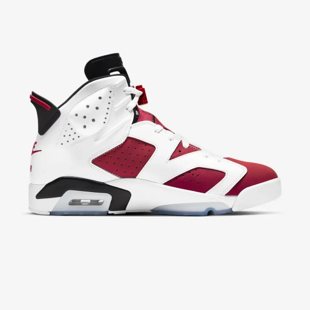 White, red, and black Air Jordan 6 “Carmine” shoe shown in side profile, featuring smooth leather overlays, perforated panels, visible Air unit in the midsole, and an icy translucent outsole