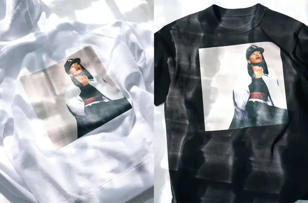 Black and white sacai T-shirts featuring Aaliyah portrait graphics, alongside a close-up of the “AALIYAH sacai” logo printed at the neckline, captured in soft, dappled lighting
