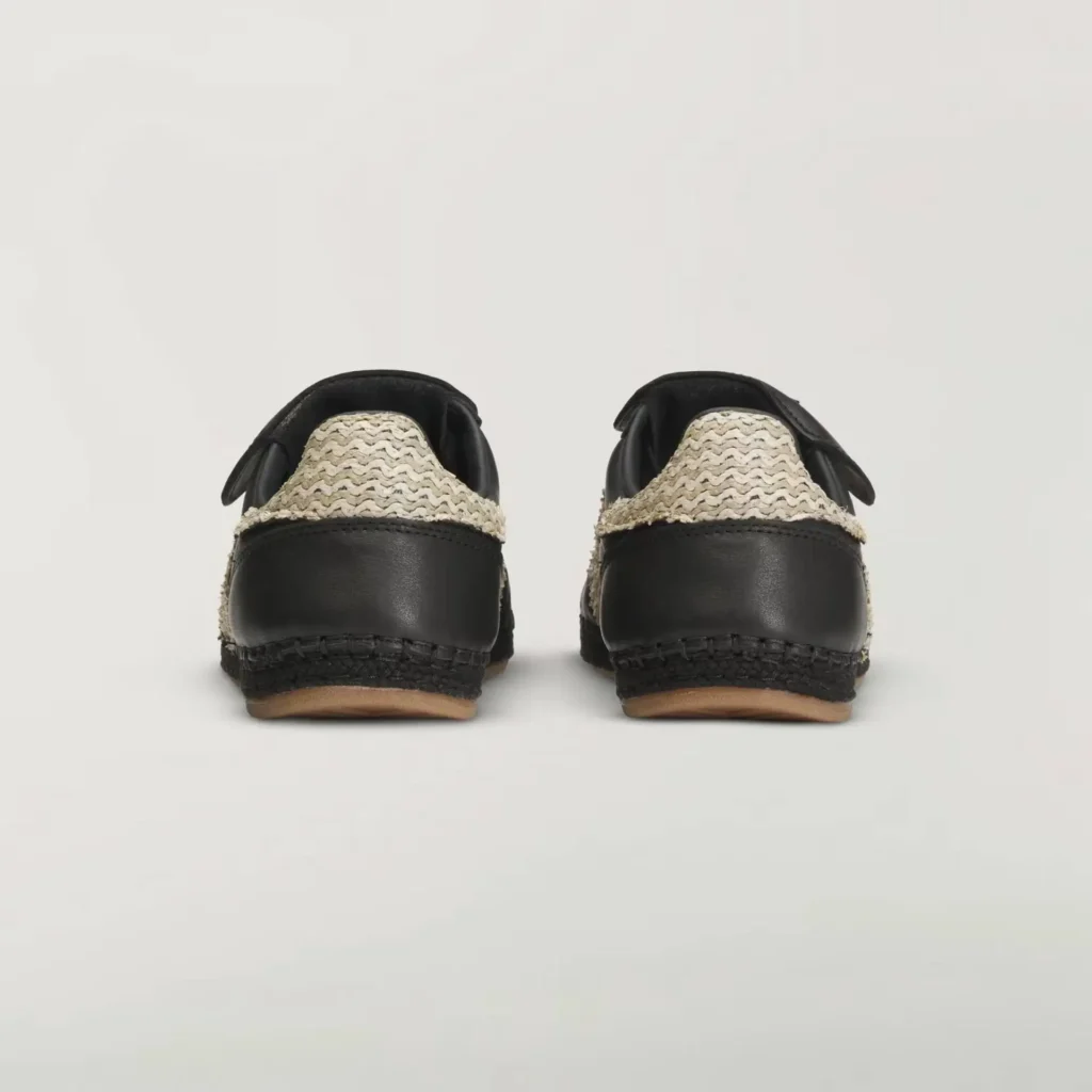 rear view of black adidas x CLOT Mundial shoe highlighting woven raffia heel panels, smooth leather overlays, and espadrille-style stitched midsoles with gum outsoles