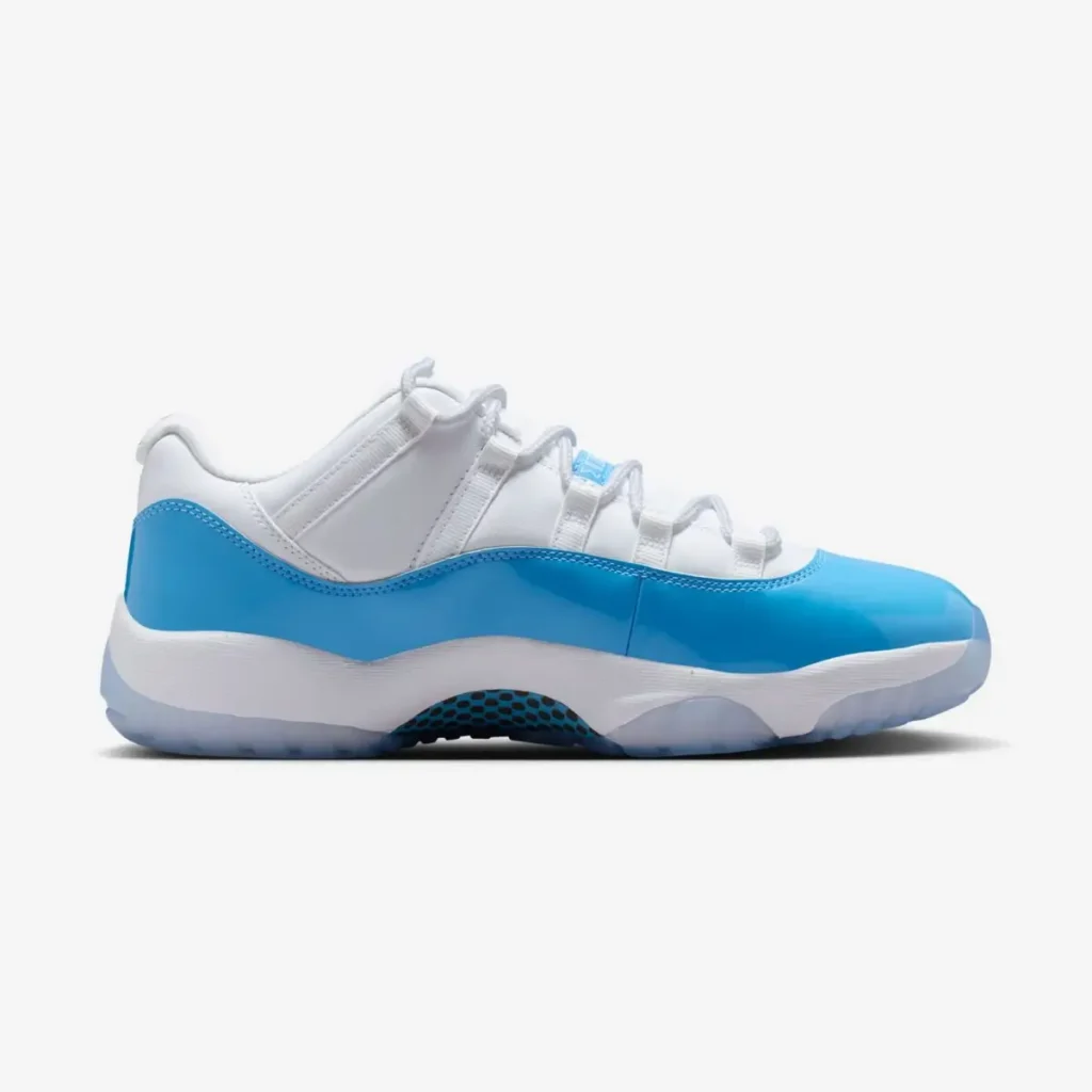Air Jordan 11 Low UNC 2026 in white leather with Carolina blue patent leather mudguard, shown in lateral side profile with icy translucent outsole