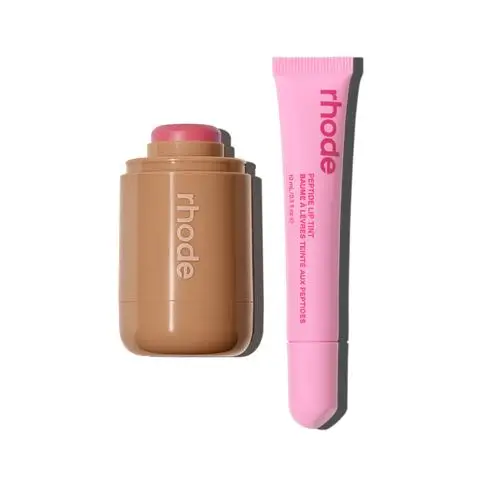 Rhode Peptide Lip Tint products by Hailey Bieber. A brown Peach-colored lip tint stick on the left and a bright pink tube of Peptide Lip Tint on the right, both featuring the signature Rhode branding against a clean white background