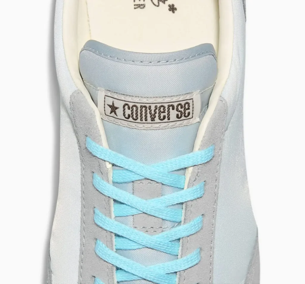 Close-up of GOLF le FLEUR* x Converse 1908 Jogger “Foggy Dew” tongue and lacing, featuring pastel blue laces, grey suede eyestay, and vintage Converse woven label