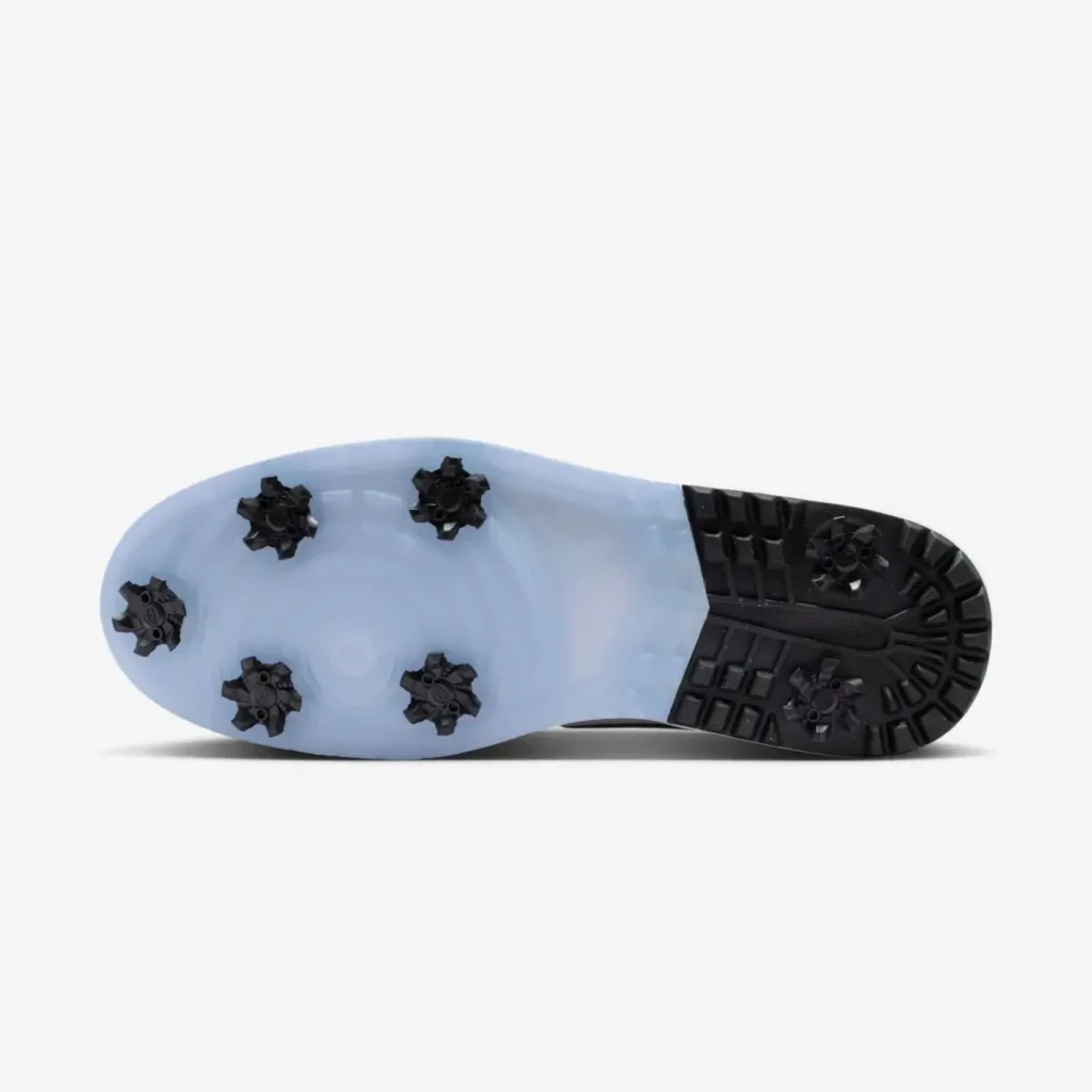 Outsole view of Air Jordan 1 Low Golf Spiked Concord showing translucent blue sole with seven removable black soft spikes and textured traction zones for grip on the course