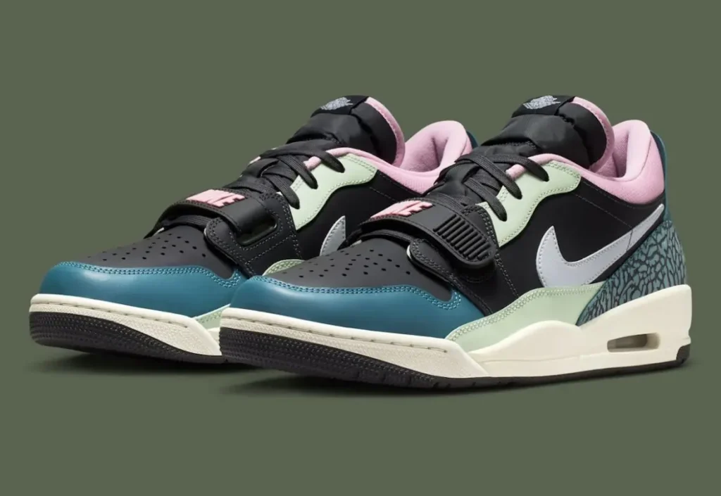 A pair of Nike Air Jordan low-top sneakers displayed side by side, featuring a bold mix of textures and colors. The shoes combine a black leather base with pastel accents—mint green overlays, a pink padded collar, and teal elephant-print detailing at the heel. A crisp white Nike Swoosh cuts across the side panels, while the forefoot strap with raised “NIKE” branding adds a retro basketball edge. The off-white midsole houses a visible Air unit, grounding the design in classic performance heritage, while the dark outsole and perforated toe box complete the layered, street-ready aesthetic