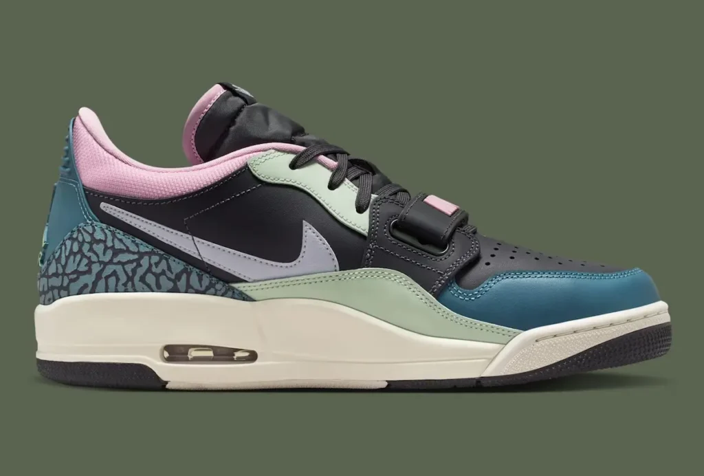 A lateral side profile of a Nike Air Jordan low-top shoe, emphasizing its layered construction and hybrid design cues. The upper features a black leather base accented by mint green panels and a teal mudguard, while a soft pink collar lining adds contrast. A light grey Nike Swoosh stretches across the midfoot, set against a backdrop of textured elephant-print detailing at the heel. The midsole appears in an off-white tone with a visible Air unit embedded near the heel, reinforcing its performance heritage. A forefoot strap and black laces complete the design, blending retro basketball elements with contemporary streetwear styling